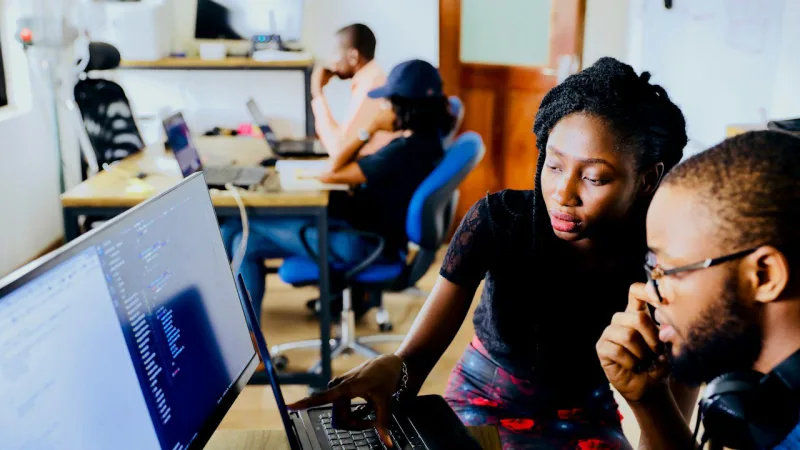 De jeunes professionnels échangent devant un ordinateur