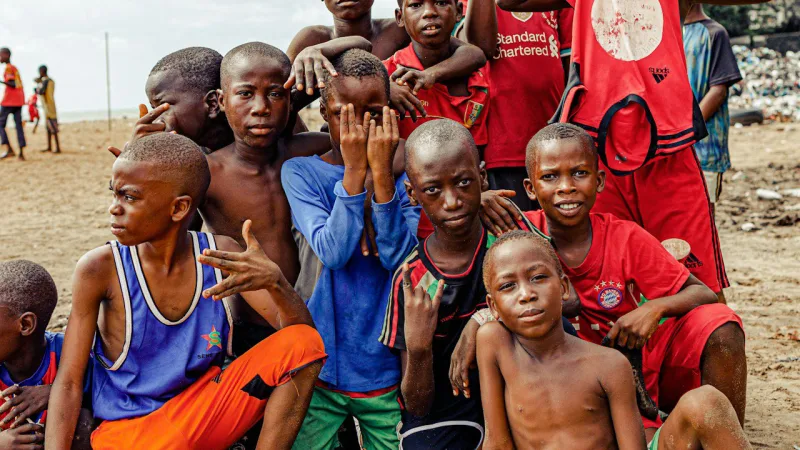 De jeunes footballeurs posent ensemble sur un terrain de sable