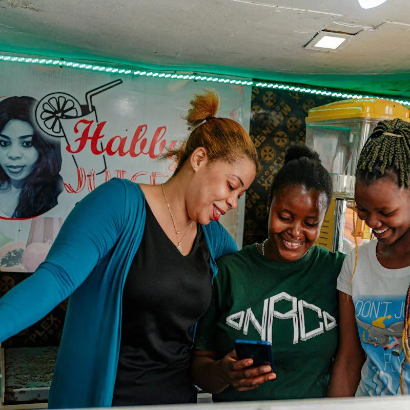 Trois femmes regardent ensemble un téléphone