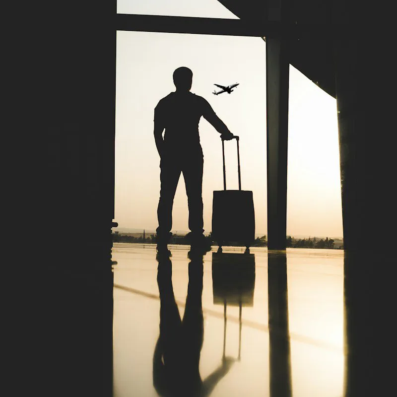 Silhouette d'un voyageur et de sa valise dans un aéroport