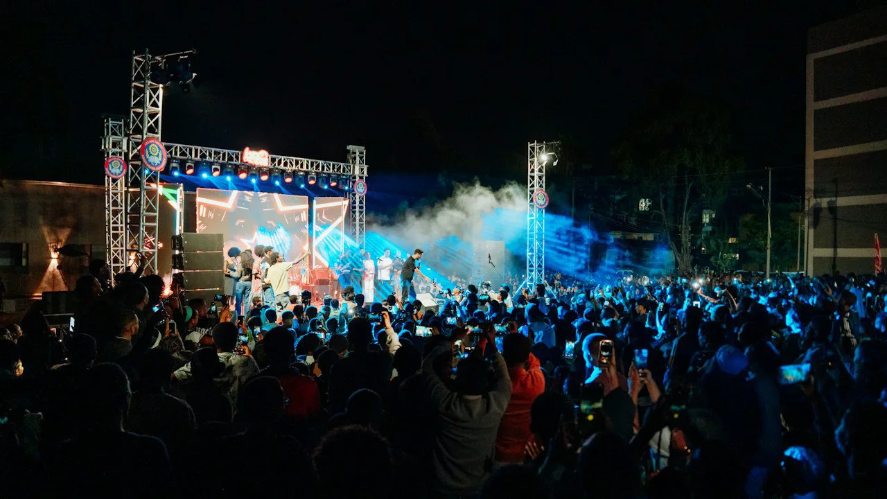 Un concert en plein air, la nuit, devant une foule nombreuse