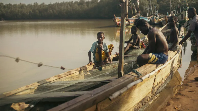 Des pêcheurs sur leur pirogue au bord du fleuve