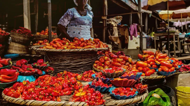 Une commerçante derrière son étal de piments et de tomates au marché