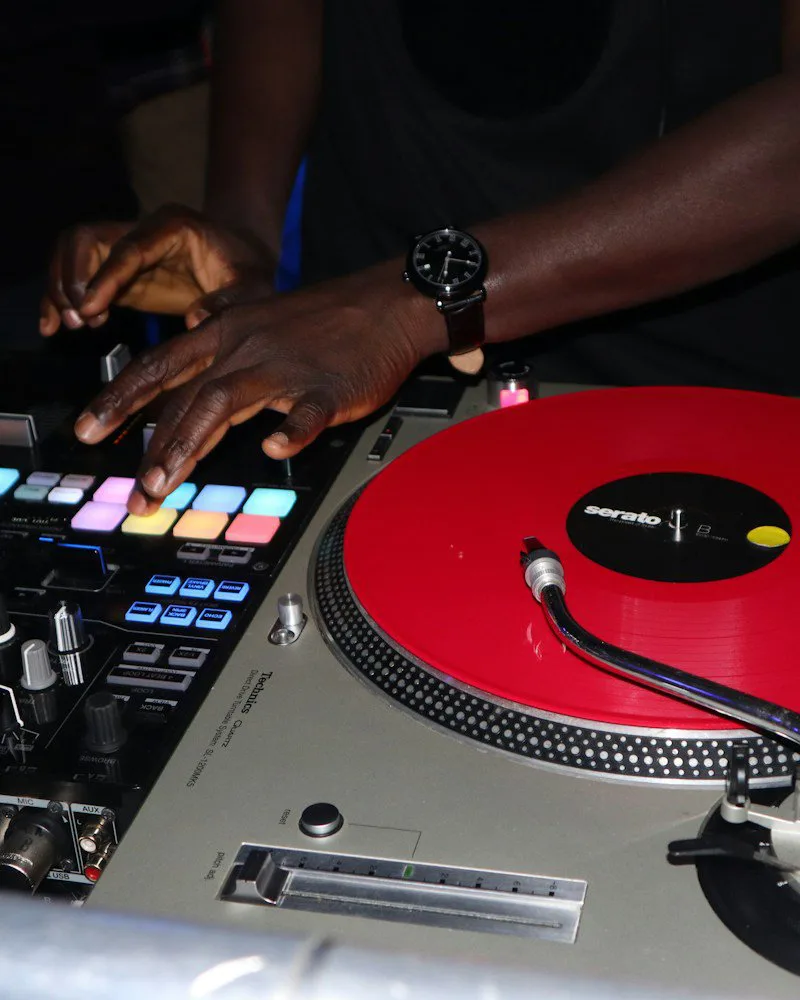 Un DJ mixe sur une platine vinyle pendant une soirée